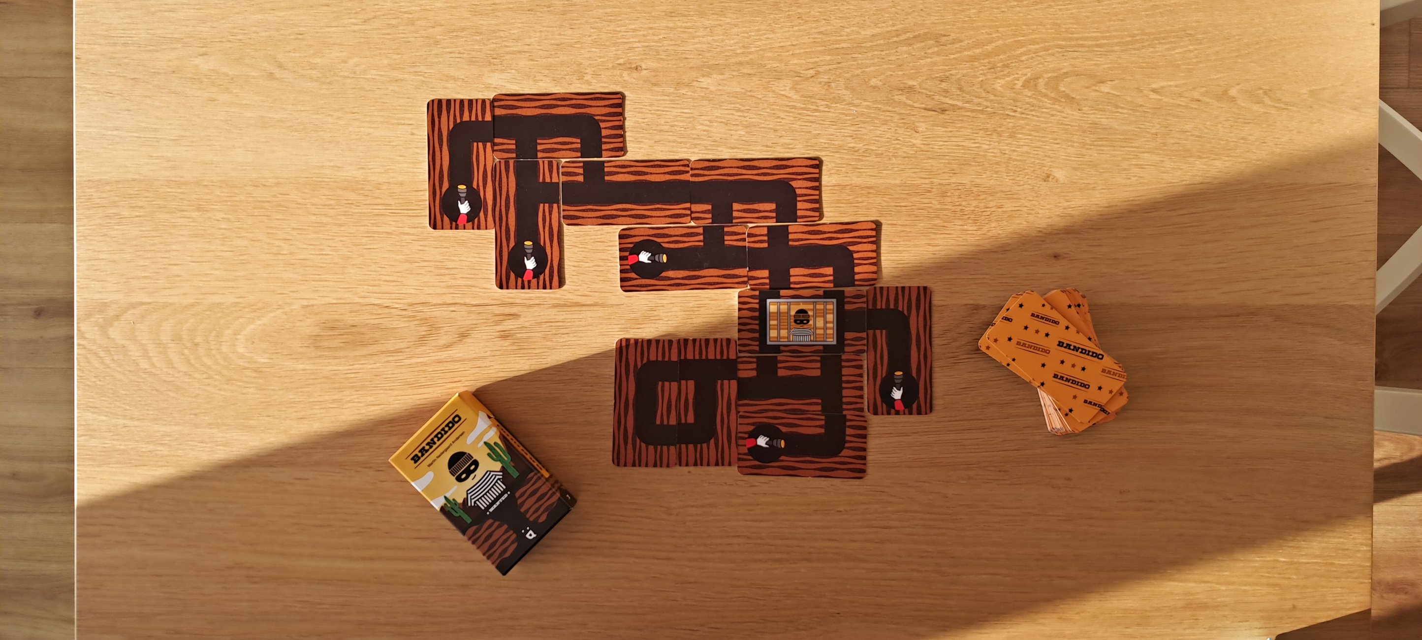 Bandido card game box, mega card with five exits and another game played