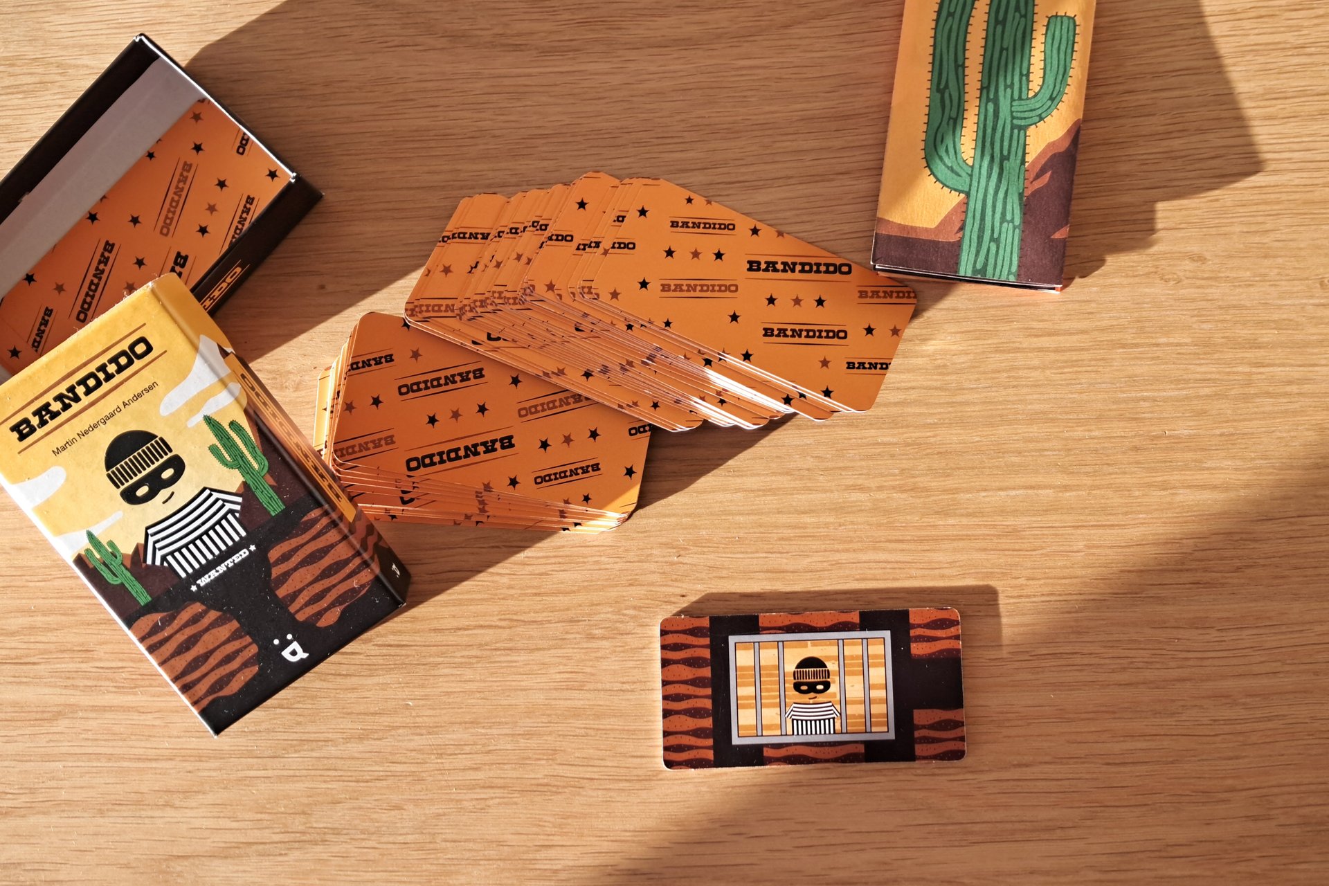 Bandido card game box, all the cards, and the mega card showing five exits