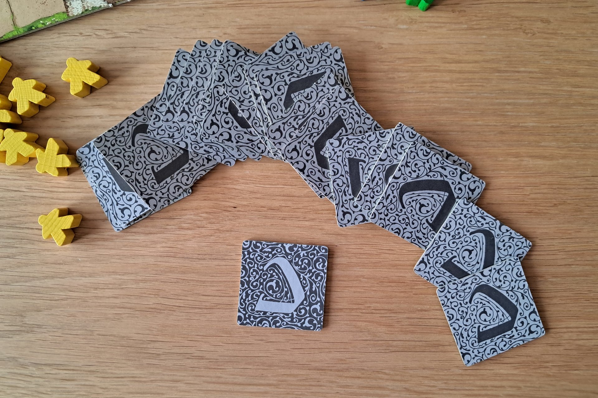 Back side Carcassonne tiles displayed together, including the start tile, which is a different color from the others