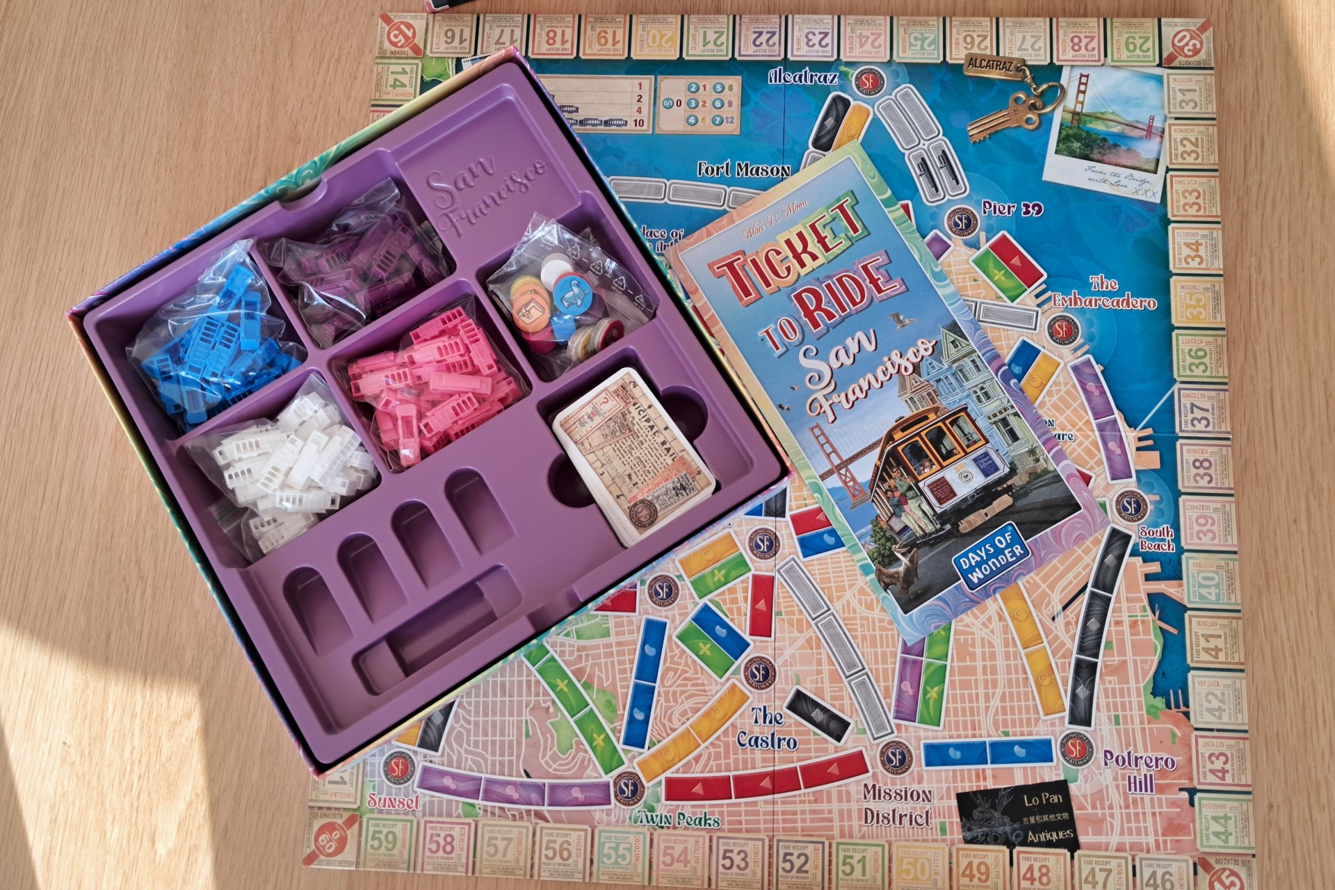 Ticket to Ride San Francisco board, rulebook, and all game components including cards, tram pieces, and tokens neatly arranged inside the box.