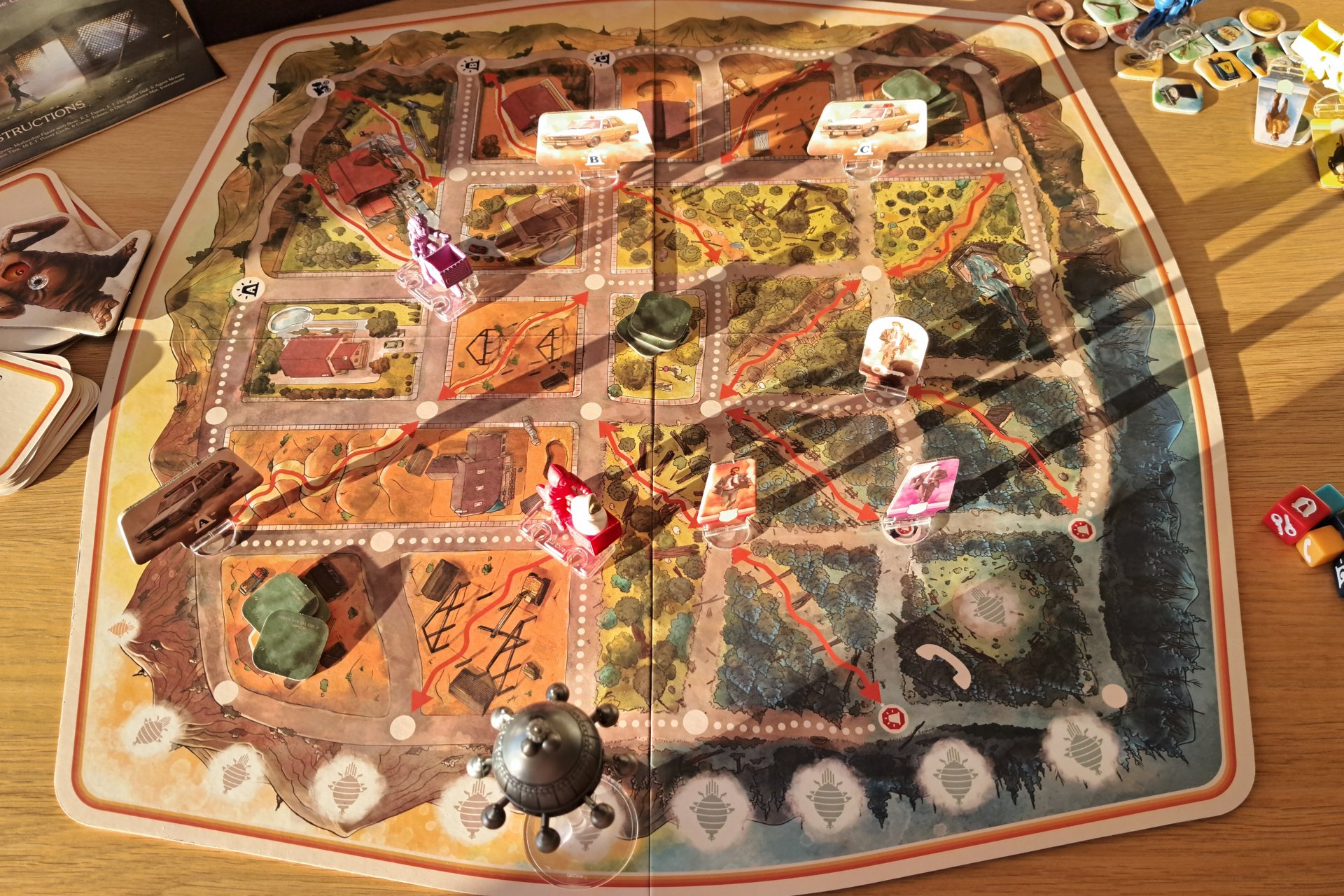 Close up of the E.T. The Extra Terrestrial Light Years From Home game board during gameplay. Several game figures are placed in the middle of the board, showing a moment from the ongoing playthrough.