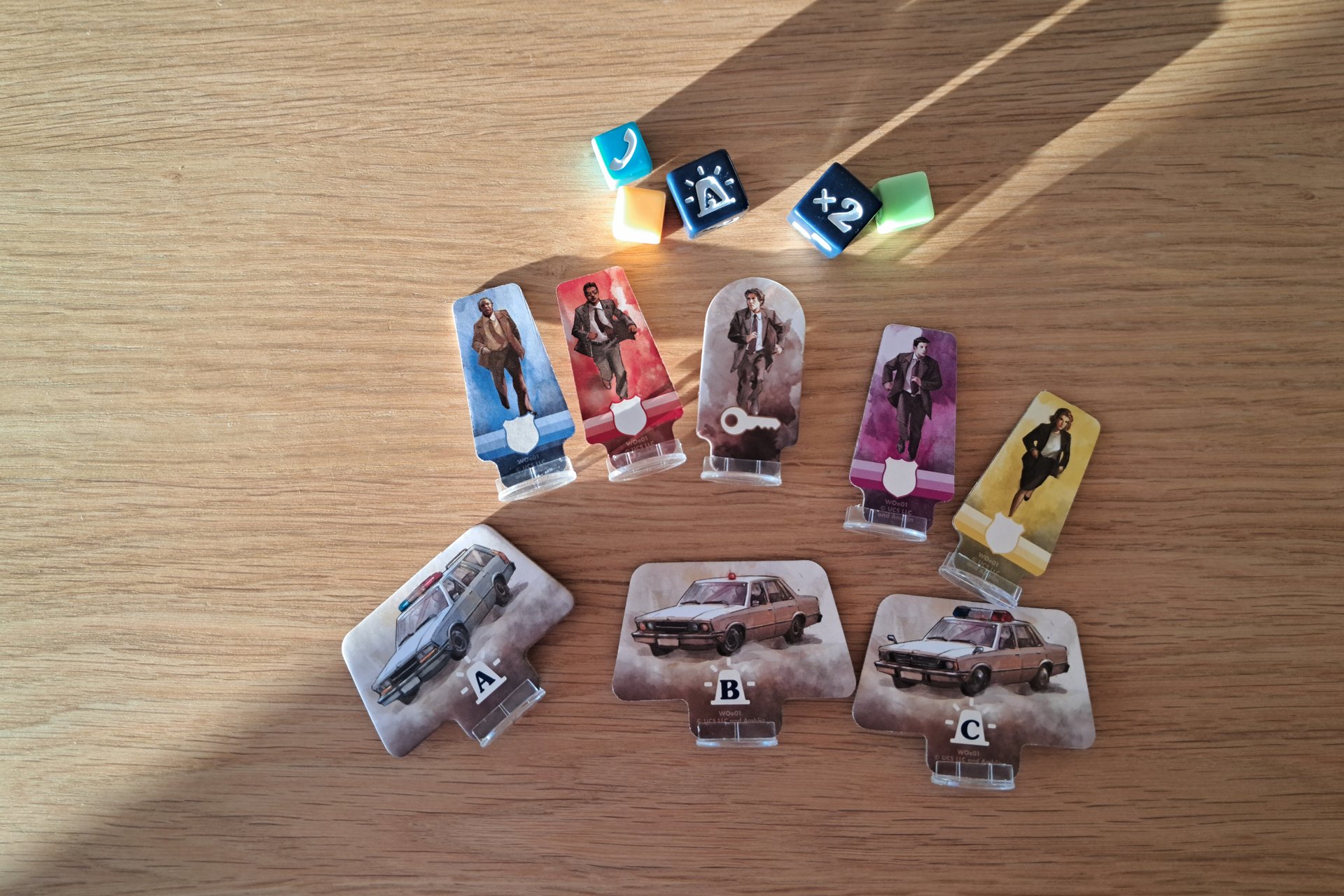 A photo showing all the agents, cop cars, and dices from the E.T. The Extra Terrestrial Light Years From Home board game.